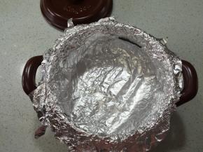 坤博砂锅用干净的厨房纸擦干净，坤博砂锅用干净的厨房纸擦干净，用锡纸铺在烤架上，以十字的方式，铺二层，贴牢砂锅内壁，顶部包住砂锅边沿