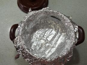 坤博砂锅用干净的厨房纸擦干净，坤博砂锅用干净的厨房纸擦干净，用锡纸铺在烤架上，以十字的方式，铺二层，贴牢砂锅内壁，顶部包住砂锅边沿