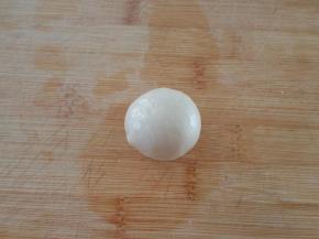 取一份水油皮擀成圆片，放一份油酥收口后捏紧