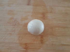 取一份水油皮擀成圆片，放一份油酥收口后捏紧