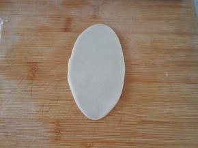 包好之后收口向下，用擀面杖擀成椭圆形