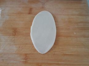 包好之后收口向下，用擀面杖擀成椭圆形