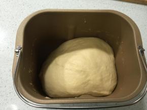 牛奶，蛋液，糖，盐、奶粉先放入面包桶里混匀，再倒入高粉，最后放上酵母，放入面包机中，操作一个和面程序后，加入黄油，再操作2至3个和面程序，拉出薄膜，放在温暖处发酵至两倍大