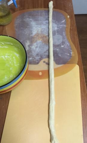 揉面至排出空气，分层4个面团，盖上保鲜膜醒面10分钟，然后搓成均匀的长条，不太好搓，可以抹点油，往前推着搓，然后捏住中间点，将面对折拧成一个两根的麻花