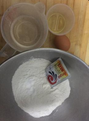 把面粉，苏打，盐，糖，搅匀，磕入一个全蛋，倒入油，初步搅合一下，把酵母倒入温水中，搅匀。