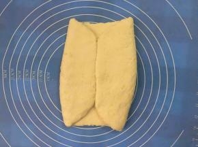 用面皮左右包起黄油片，盖上保鲜膜松弛20分钟