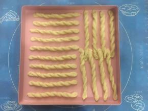 小条面片两头反方向扭转，排在烤盘上，两头稍稍用力在烤盘上压一下，起固定作用