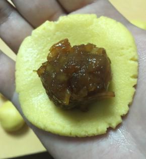 将面团按平，放置虎口，一点点收紧手中的面团，将馅球包好，轻轻揉圆