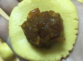 将面团按平，放置虎口，一点点收紧手中的面团，将馅球包好，轻轻揉圆