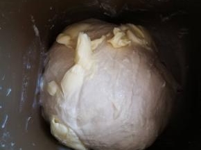 启动揉面程序 时间依个人面包机而定，一般是20分钟左右，面团表面光滑了，这时加入软化的黄油和盐