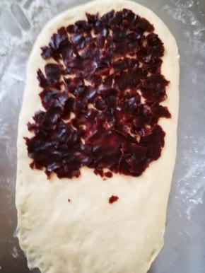 将豆沙压成薄片，薄薄的，均匀的铺在面团上