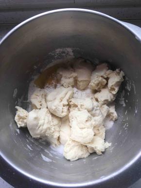主面团里除去油和盐以外的所有材料倒入盆里，加入撕成小块的中种面团。揉到扩展阶段。