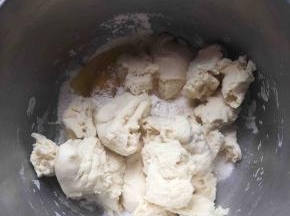 主面团里除去油和盐以外的所有材料倒入盆里，加入撕成小块的中种面团。揉到扩展阶段。