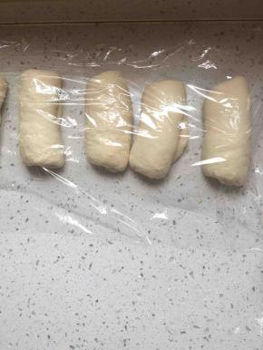 松弛好的面团擀成椭圆形，卷起，再松弛三十分钟。