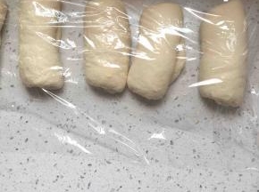 松弛好的面团擀成椭圆形，卷起，再松弛三十分钟。