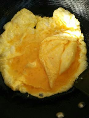 热火，倒入油，把打散的鸡蛋慢慢倒入锅中，摊平。