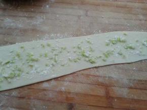 将剩余的饺子皮撒低粉擀成长条，抹油，撒点盐，撒葱沫，最后上层撒点干粉