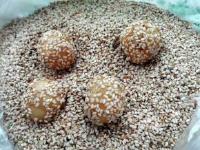 将小圆球放入芝麻中滚一下，很容易沾满芝麻