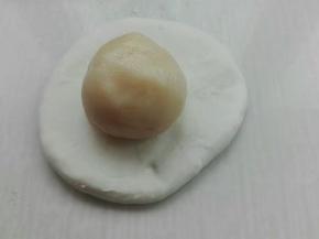 取一个面团擀成圆形，包入一个油酥