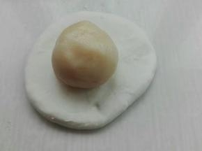 取一个面团擀成圆形，包入一个油酥