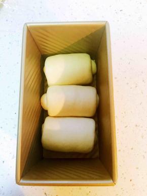 松弛好了再将面团擀成牛舌状，卷2.5圈
放入吐司模