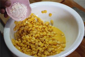 玉米沥干水分，加一个蛋黄让玉米粒均匀的裹上蛋液，然后加入少量的吉士粉和淀粉搅拌均匀，让玉米粒均匀的裹上面糊