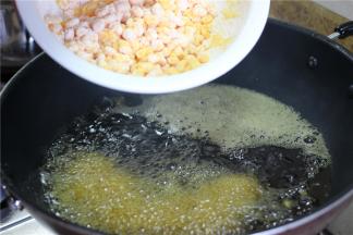 锅内倒入适量油，油热之后放入拌好的玉米粒，炸至玉米粒上的面糊起酥即可捞出。要注意油温的控制，等到油烧的冒烟放入玉米粒，油温低了面糊会脱粉；二是放入油锅之后不要去动，等外面的淀粉炸成型，才可以翻动，翻动的时候不要太大力，否则淀粉壳会跟玉米粒脱开。