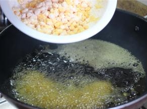 锅内倒入适量油，油热之后放入拌好的玉米粒，炸至玉米粒上的面糊起酥即可捞出。要注意油温的控制，等到油烧的冒烟放入玉米粒，油温低了面糊会脱粉；二是放入油锅之后不要去动，等外面的淀粉炸成型，才可以翻动，翻动的时候不要太大力，否则淀粉壳会跟玉米粒脱开。