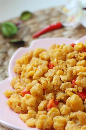 下入青红椒翻炒均匀即可出锅。做好的金沙玉米一定要趁热吃哦，酥脆咸香，再也不用担心宝宝不爱吃饭了