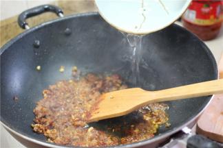 等到肉末全部变色，加入小半碗水焖煮