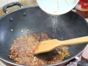 等到肉末全部变色，加入小半碗水焖煮