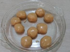 将转化糖浆倒入。 加入花生油（色拉油）搅拌均匀，再放入枧水，搅拌均匀。筛入面粉和奶粉。 用刮刀，自上而下，用“切、切、切”的方式，不停地剁面。 和成面团，将面团放入保鲜袋静置1小时，饼皮分成25克每个