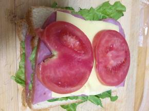 为了三明治更营养丰富一些，再依次把吐司片，生菜，火腿片，芝士，西红柿片和吐司加盖一层。