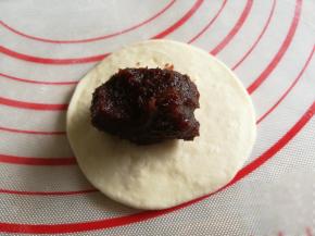 把面团用面杖换成圆形，包入豆沙馅。