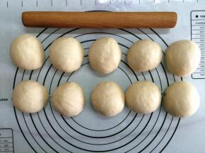 将发好的面团从面包机内取出，排气后均分成10个小面团，滚圆后盖上保鲜膜进行松弛10分钟。