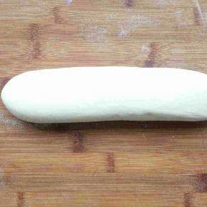 将面团平均分成两块，取其中一块搓成长条并压扁