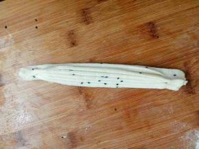 用手捏住两头轻轻拽长，抻长以前可以撒点芝麻也可以不撒