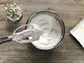 蛋白分三次打入细砂糖50克，打至坚挺长弯勾。