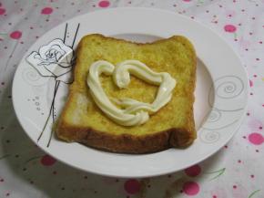 在煎鸡蛋的同时，煎好的一片土司片上挤入一些适量的沙拉酱