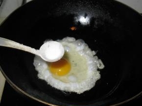 鸡蛋煎至快凝固时，散上一些盐