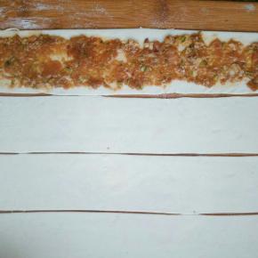 在每一条都抹上调好的肉馅，注意两个边缘不要抹