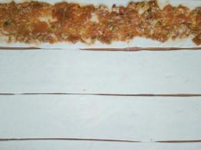 在每一条都抹上调好的肉馅，注意两个边缘不要抹