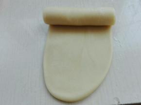 包好的剂子擀成椭圆形，自上而下卷起来