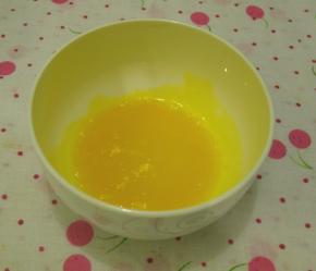 水加糖倒在锅里加热煮成糖水，到沸腾后关火。一边用打蛋器搅打，一边慢慢倒在蛋黄糊里，混合成蛋黄糖水，是为了将生蛋黄杀菌。放一边先降温