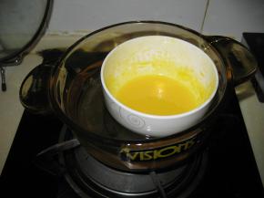 水加糖倒在锅里加热煮成糖水，到沸腾后关火。一边用打蛋器搅打，一边慢慢倒在蛋黄糊里，混合成蛋黄糖水，是为了将生蛋黄杀菌。放一边先降温
