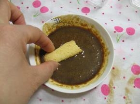 取一片手指饼在咖啡液里蘸一下