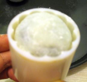 将冰皮放入模具里，模具口放在案板上，按住模具柄稍用力往下压