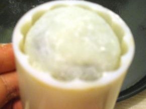 将冰皮放入模具里，模具口放在案板上，按住模具柄稍用力往下压