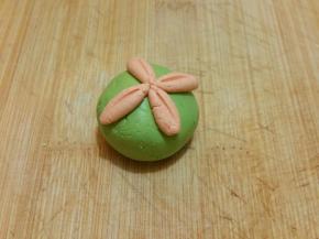 然后用牙签按出形状，中间加一个圆形小面团，即可以做出花的形状