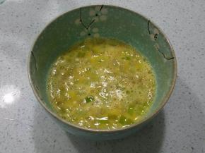 打散的鸡蛋中放入切碎的青椒丁（如果不喜欢辣可以不放）